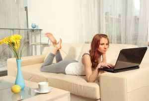 Mujer con computadora portátil laptop en un sofá