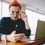 Hombre con smartphone y portátil