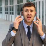Hombre hablando por dos smartphones
