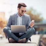 Hombre con portátil y smartphone