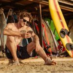Hombre con smartphone en la playa